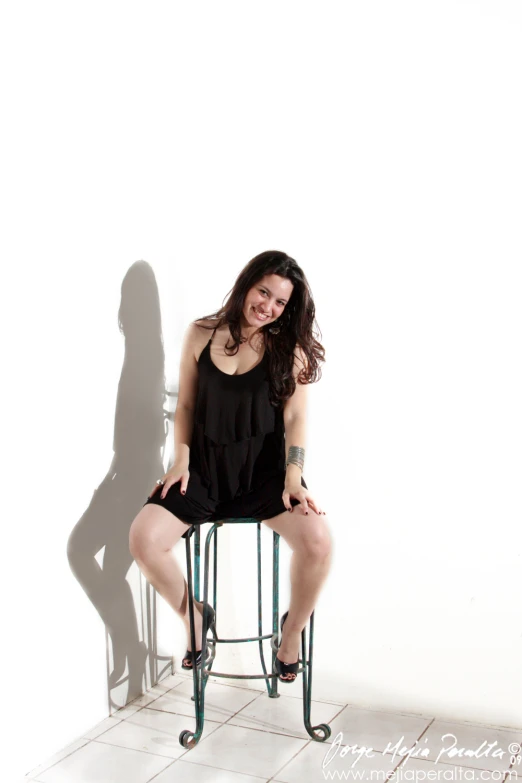 a beautiful woman sitting on top of a metal chair