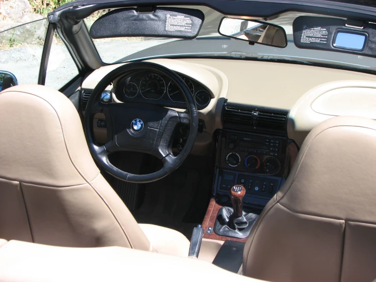 a small tan car with the dashboard down