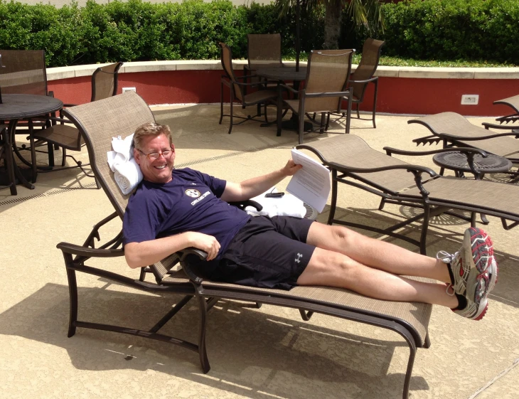 a man lounges with his legs crossed on a bench