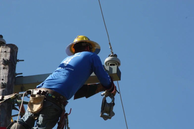 an electrician adjusting a pole on a power line