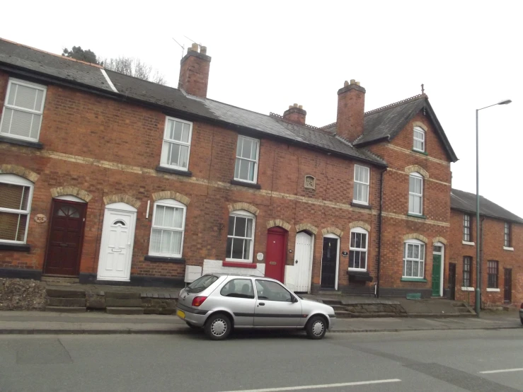 there is a car parked on the street outside houses