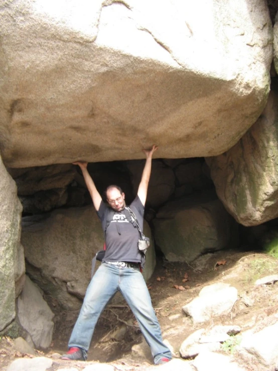 there is a man in the middle of climbing up a mountain