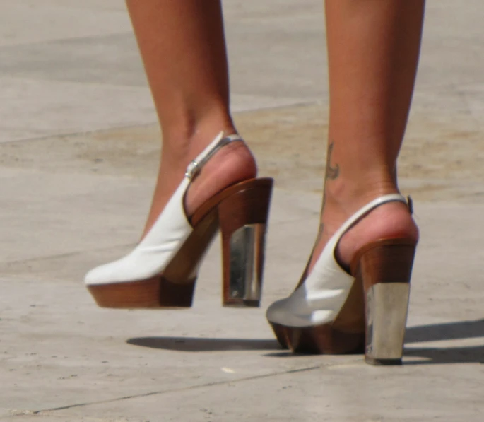 the legs of a women in heels with her shoe covered