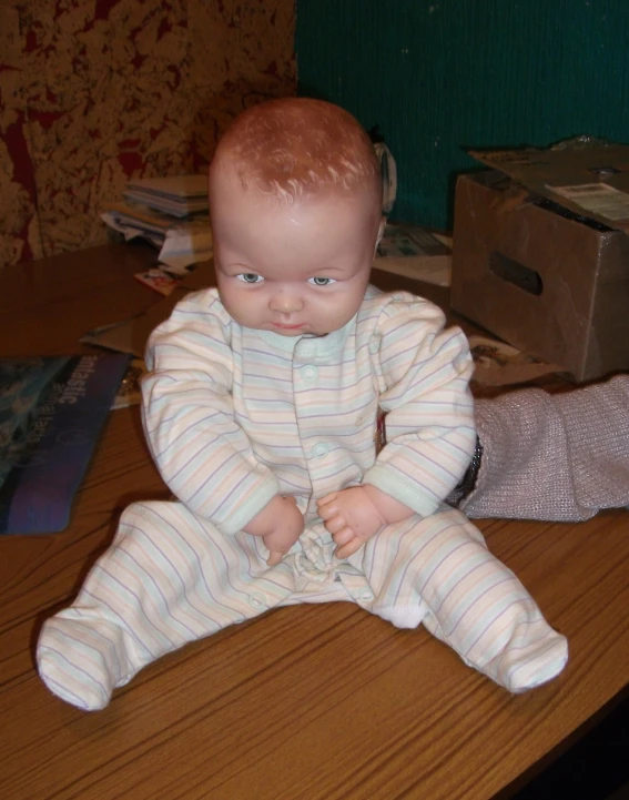 a young baby sits on a desk in pajamas
