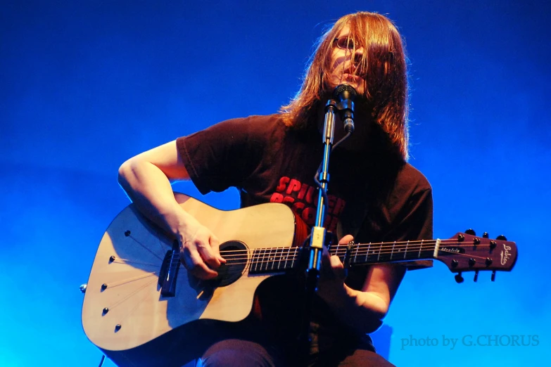 a man playing a guitar on stage at a concert