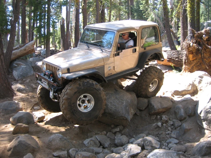 an off road jeep is driving over some rocks