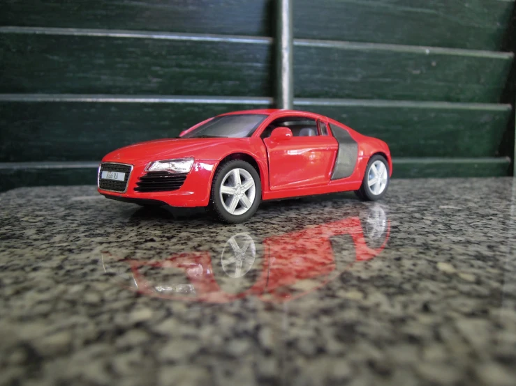 a small red toy car parked on a table