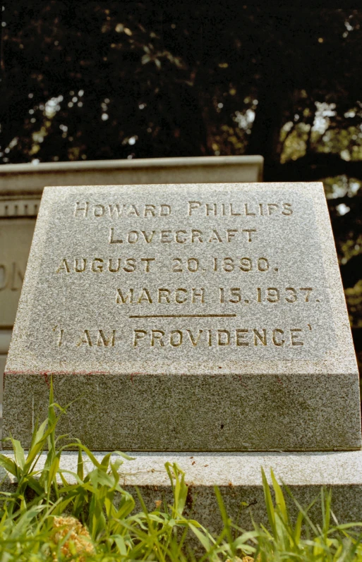 a headstone with writing on it in the grass