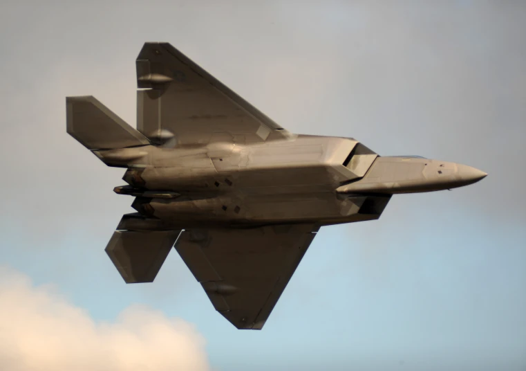 a military plane in the sky with it's landing gear down