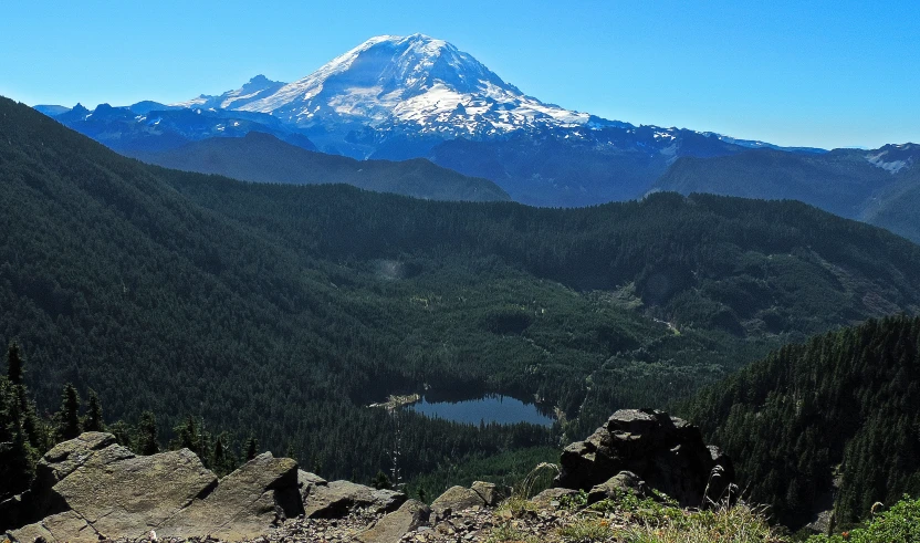 a scenic view of some mountains and lake in the foreground