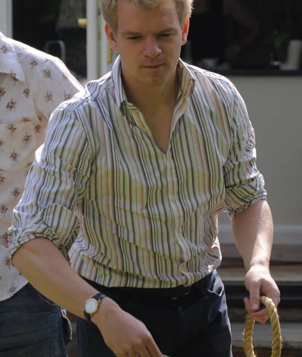 a man holding a round handle while looking down at it