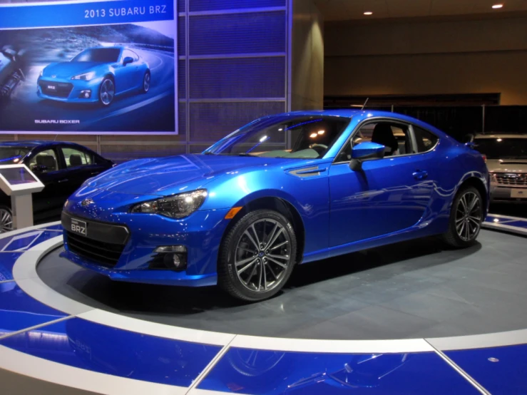 a blue sports car parked on a show floor