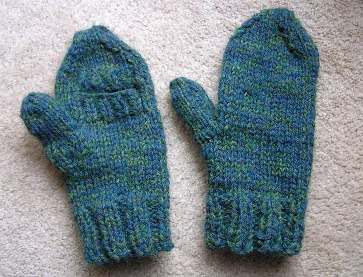 two blue gloves are sitting on the carpet