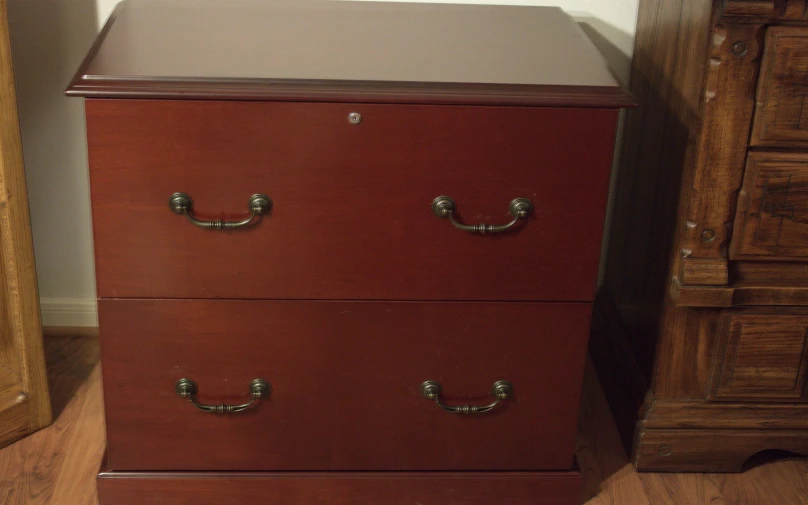 a brown wooden cabinet with silver handles sits on the floor