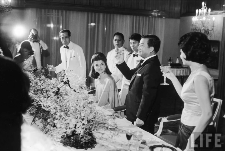 a group of people standing around a dinner table