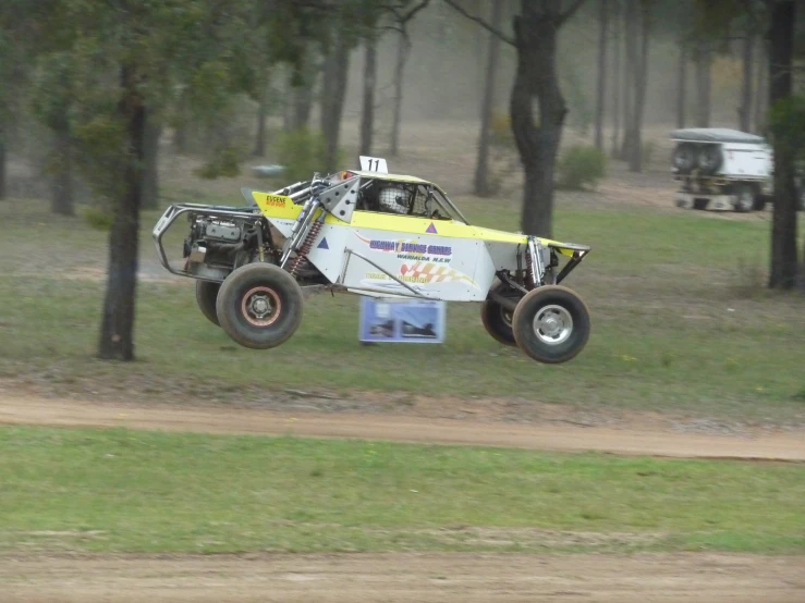 a large truck making it's way through the trees in the mud