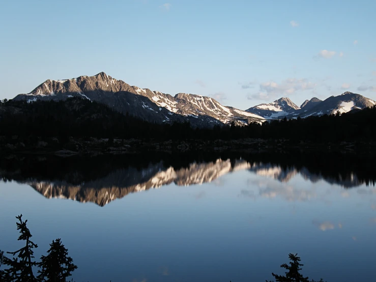 a large mountain is in the distance over water