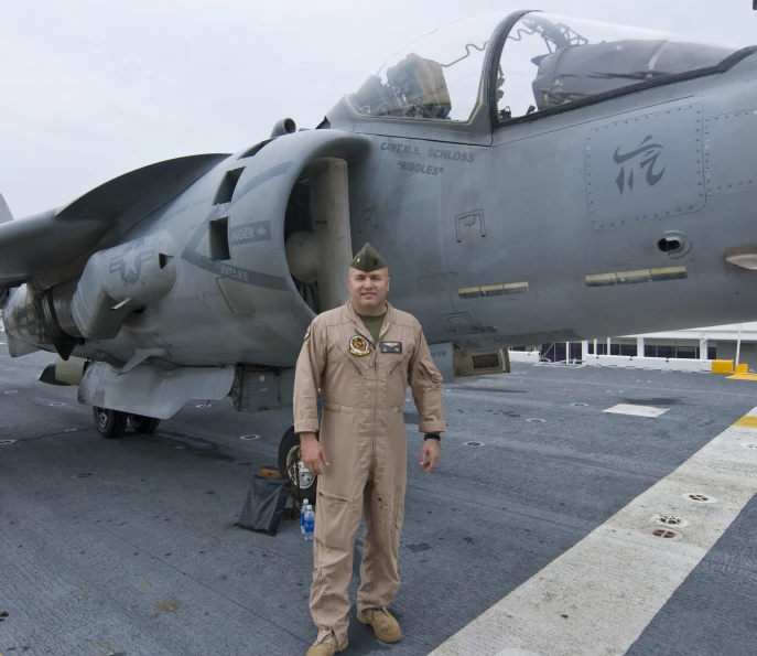 the man is standing near the airplane on the runway