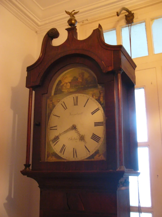 a very large wooden clock sitting in a corner