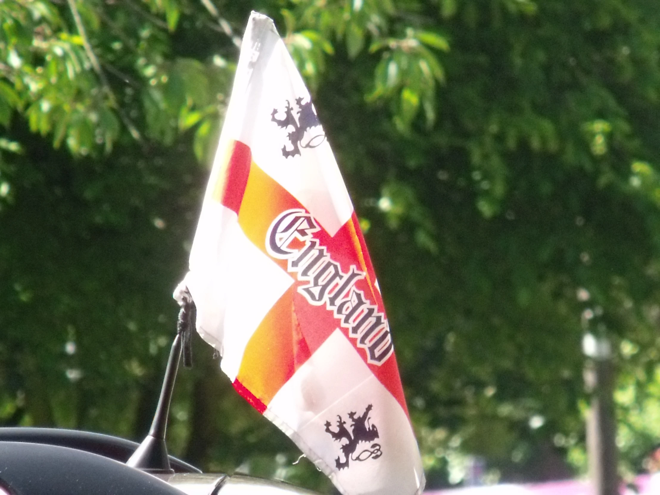 small flag hanging from the roof of a car