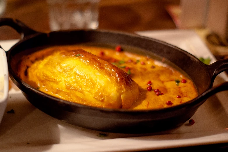 an omelet with yellow sauce is being served in a set