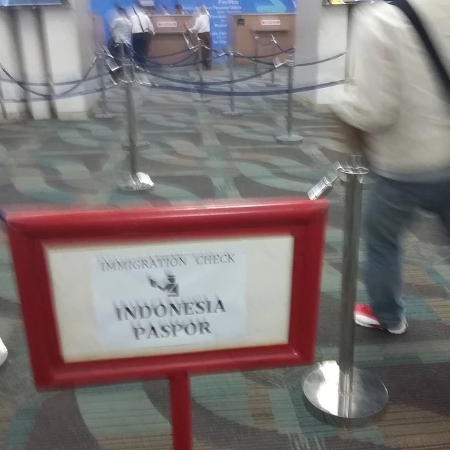 a red and white sign sitting in the middle of a hallway