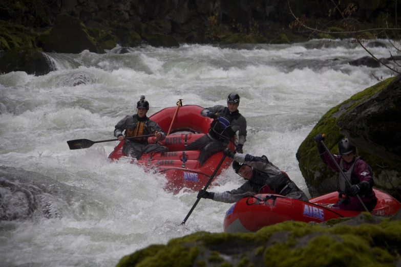 three people on rafts ride through white water