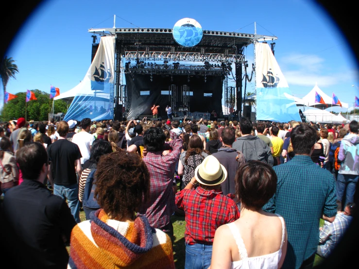 a crowd of people on the grass near a stage