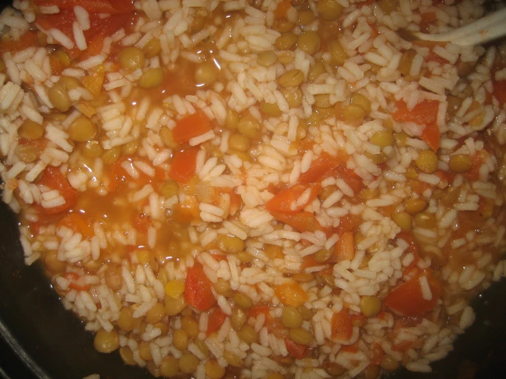 some food is in a pot that has carrots and rice