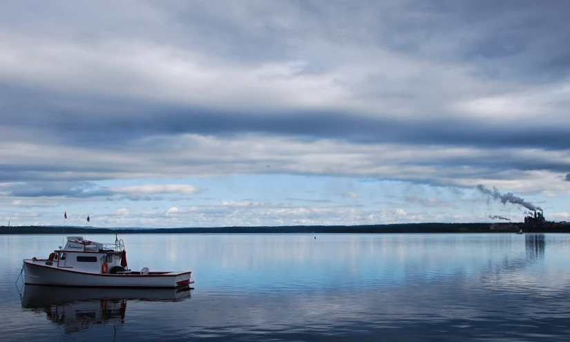 a boat is anchored at a lake with smoke