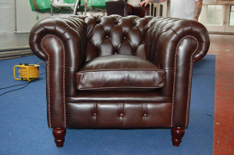 a man is working behind a desk with an old fashioned brown leather chair