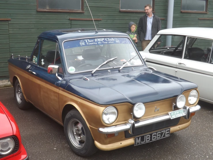 a blue and brown car with a man in the back