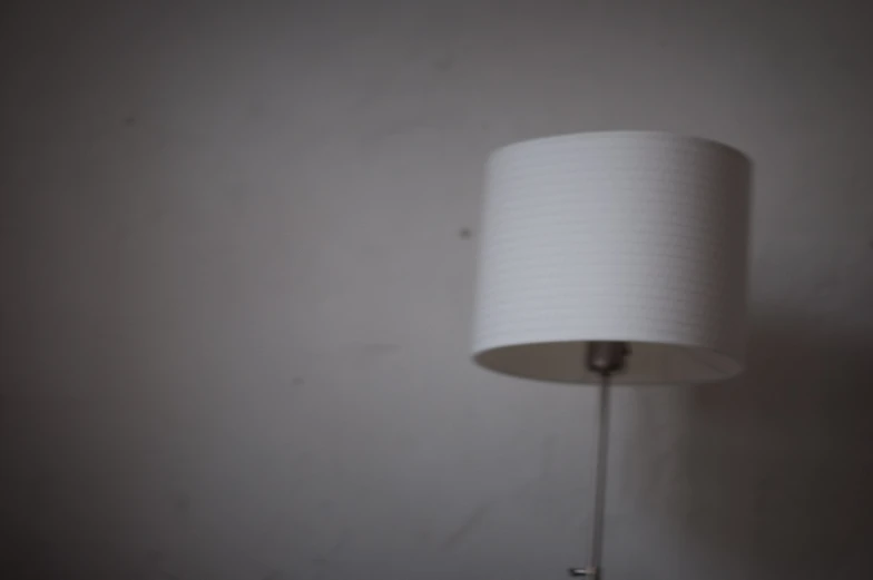 a lamp shade in white against a plain wall