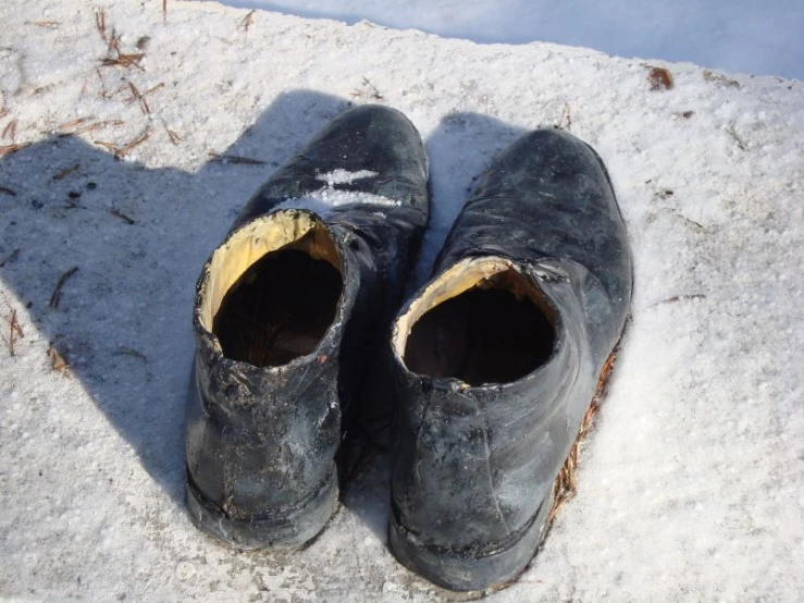 pair of worn shoes on snow in daytime