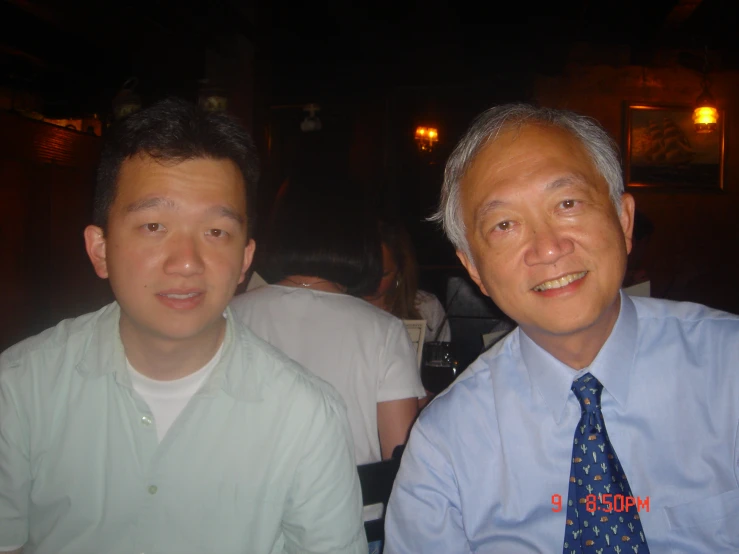 two men who are wearing neck ties sitting next to each other