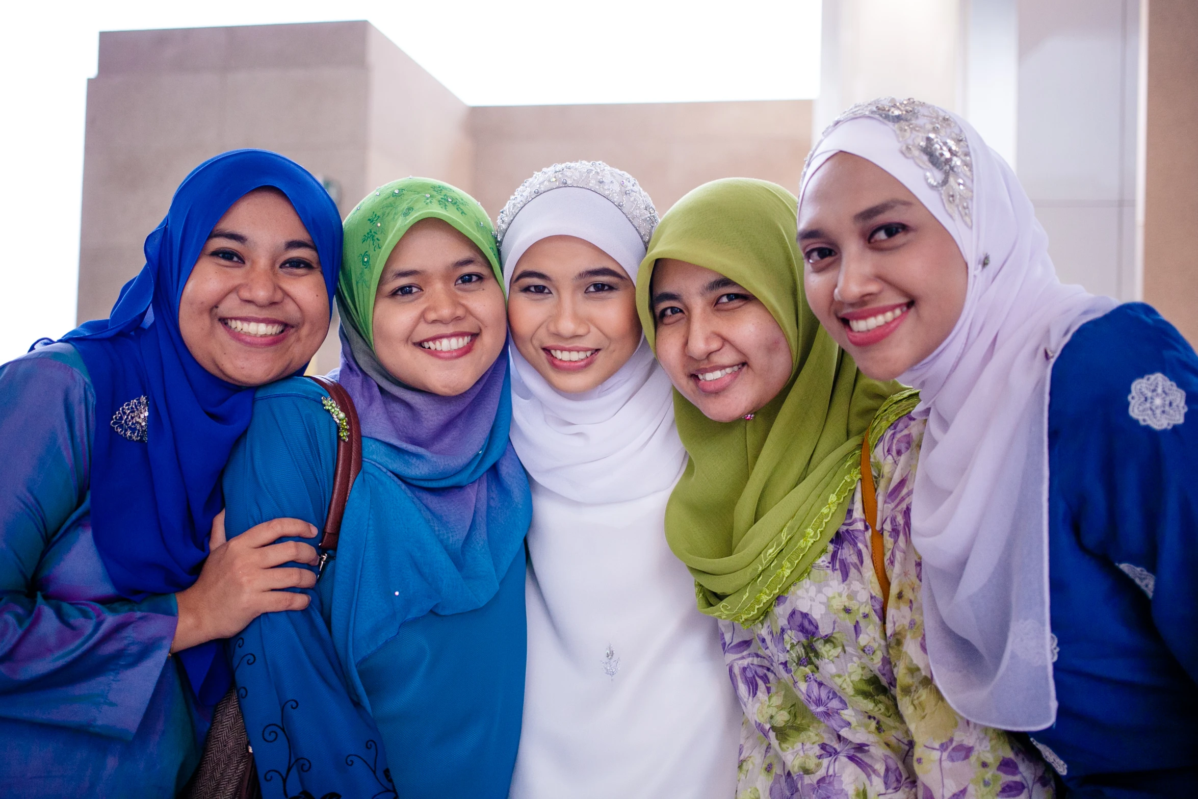 women dressed in colorful headscarves posing for po