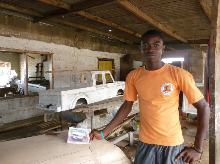 a man stands next to his truck in an unfinished garage