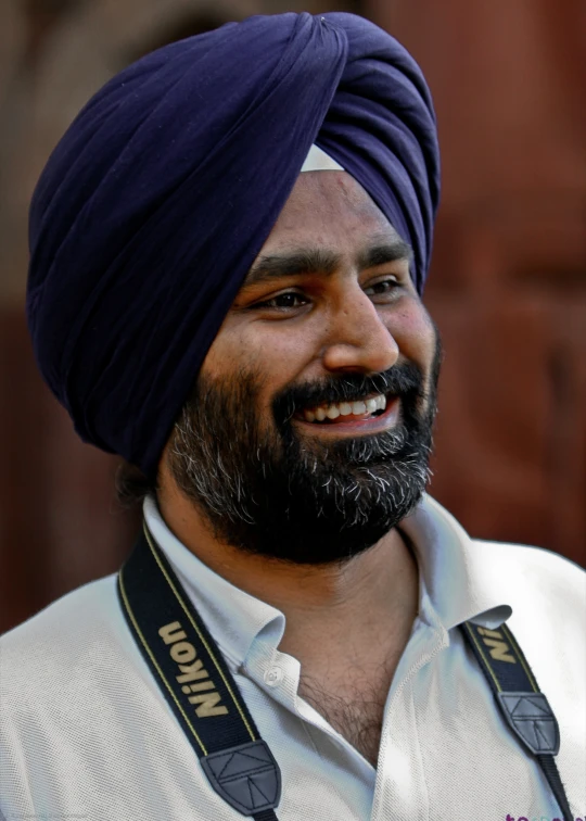 man with blue turban, wearing a camera around his neck