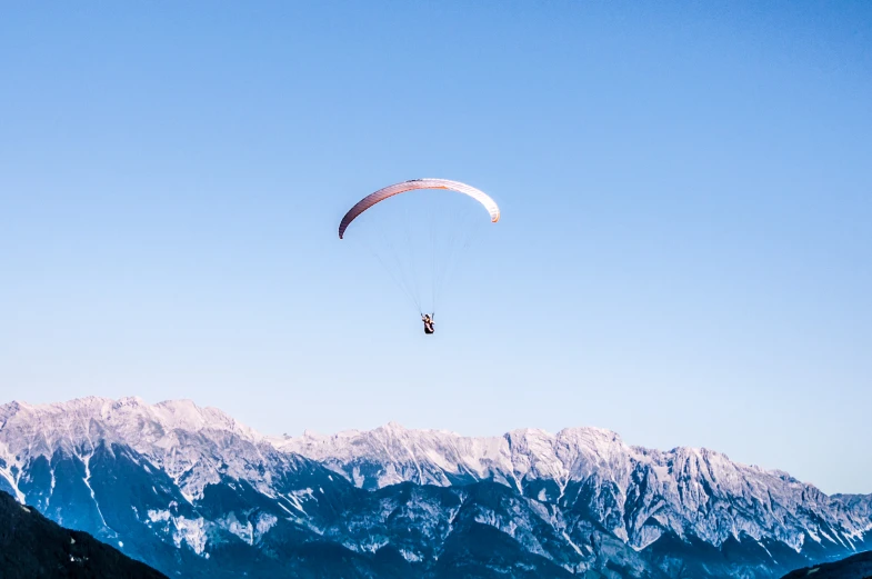 an outdoor view of some mountains with a person parachuting