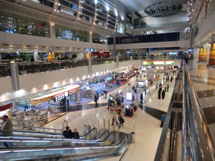 people on escalators in a large airport terminal