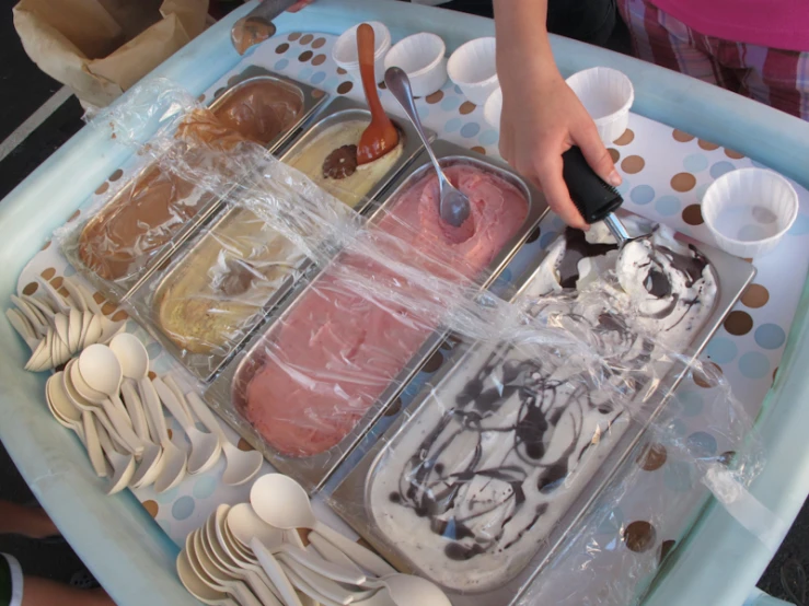 a tray with ice creams, chocolates, and spoons in it