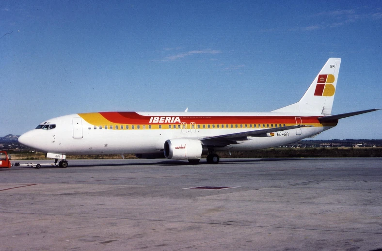 an airplane sits on the ground near some other planes