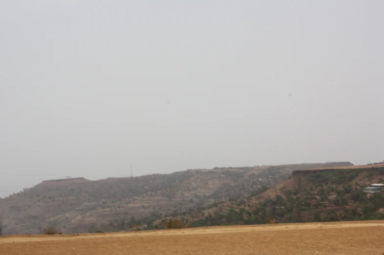 a lone airplane flies over an open grassy field