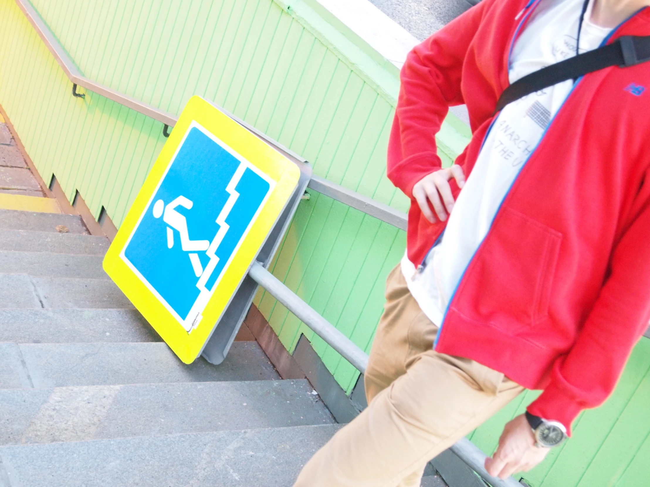 a person in red jacket standing next to a yellow sign