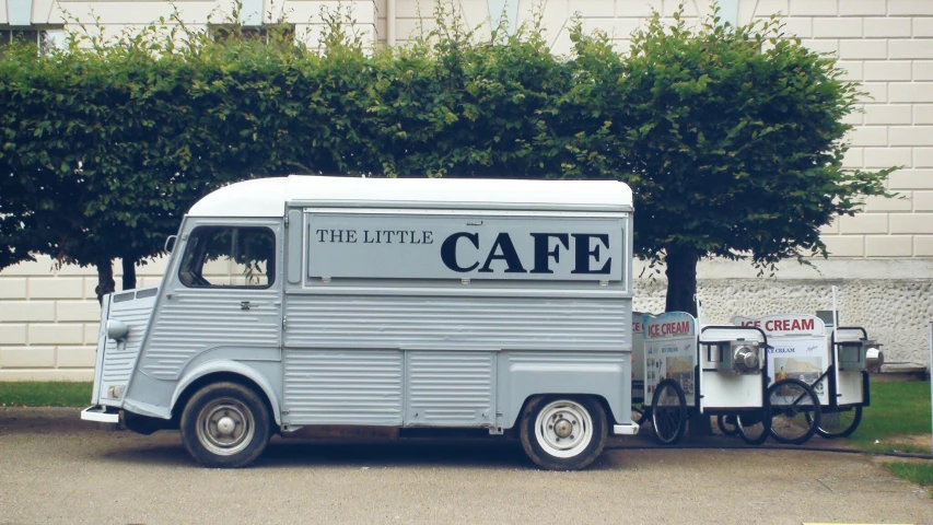 the coffee truck has a bike and coffee cart beside it