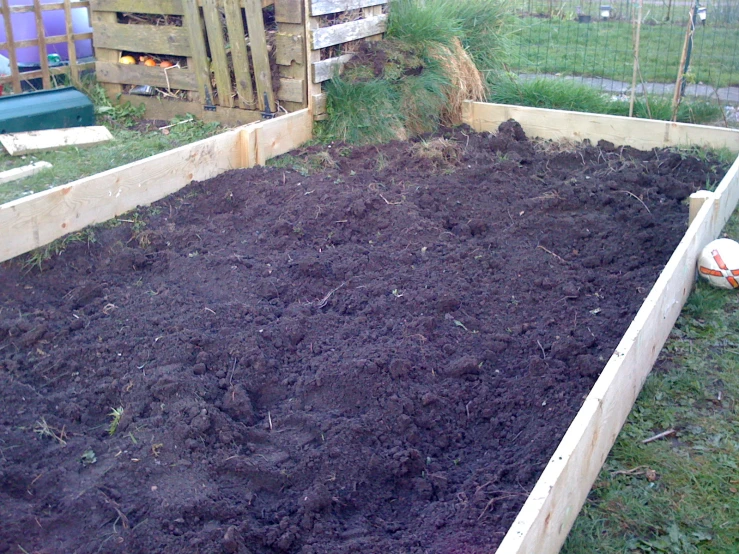 a vegetable garden area with composted boxes and soil