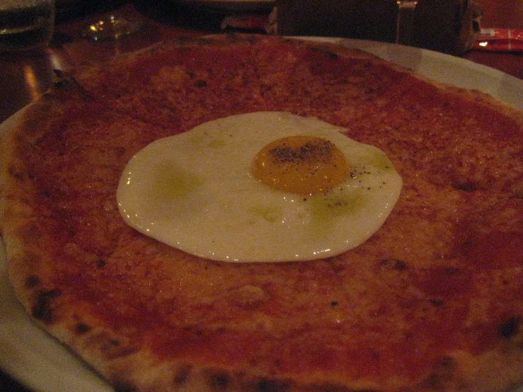 an egg on a pizza is in the shape of a heart