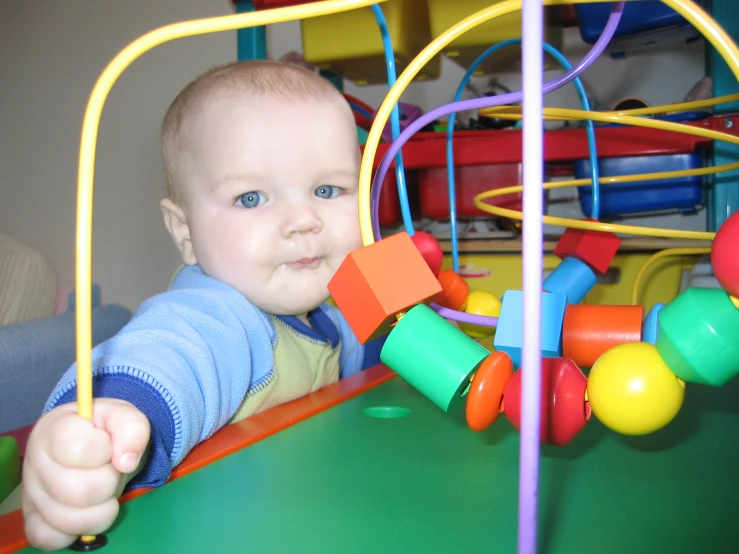 baby plays with a colorful toy in a room