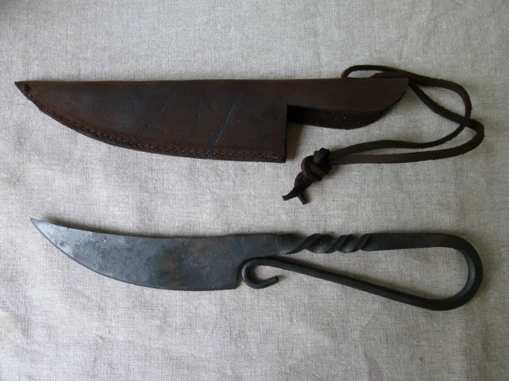 two knives sitting next to one another on a white surface