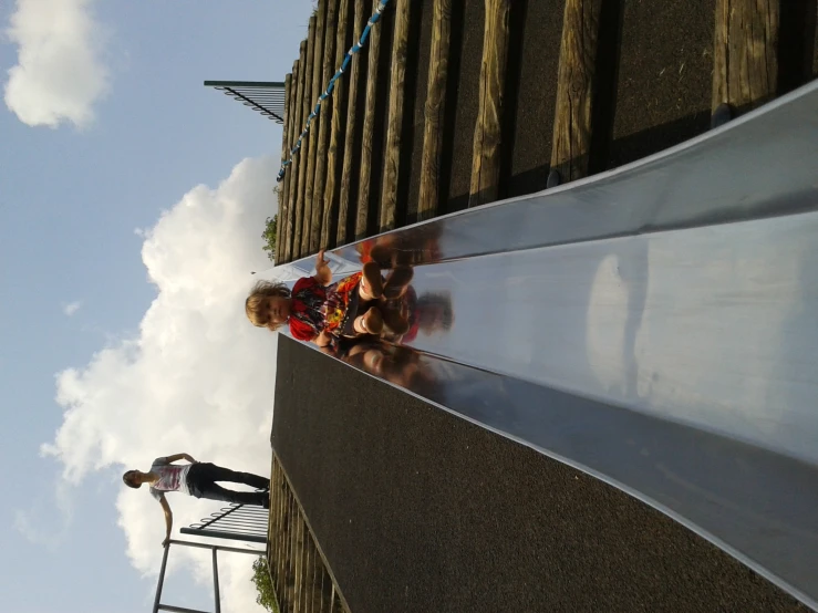 a  riding down a slide next to an adult